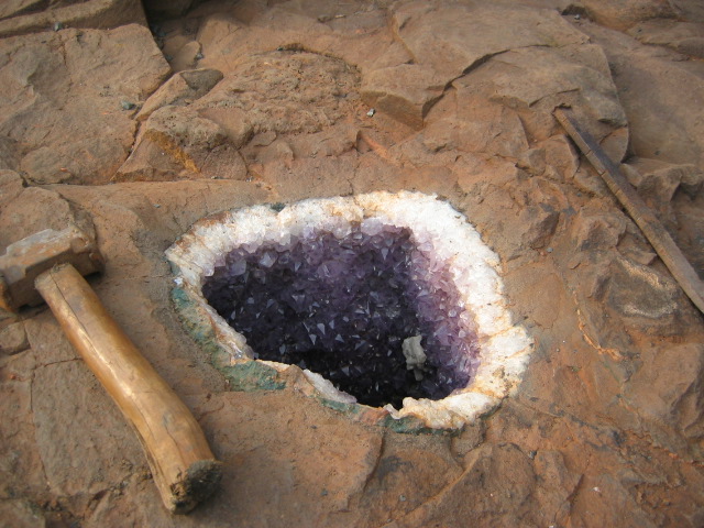Amethyst geode lined with purple quartz crystals inside a hollow nodule