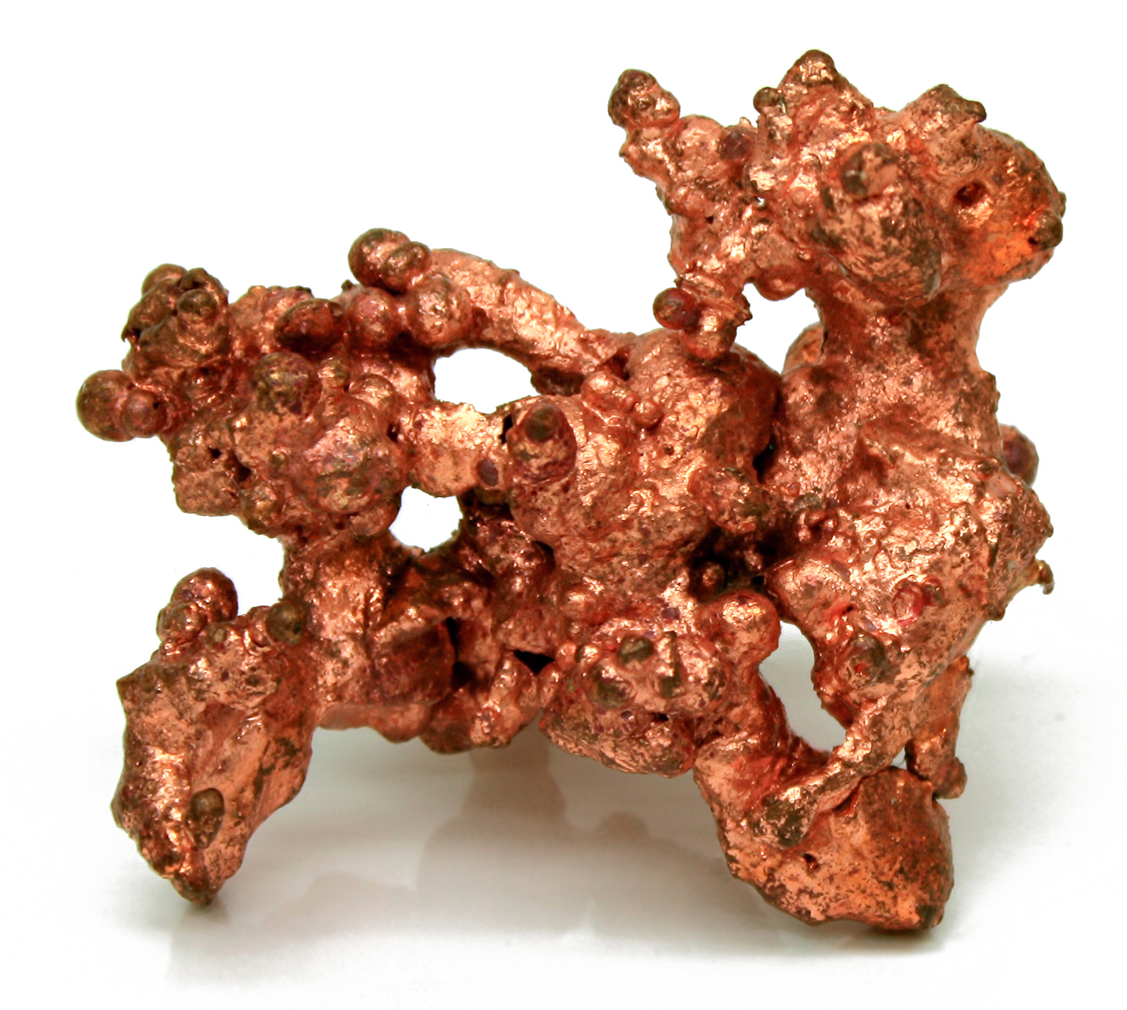 Bright reddish native copper specimen with a dendritic metallic surface, a malleable and ductile mineral illustrating tenacity